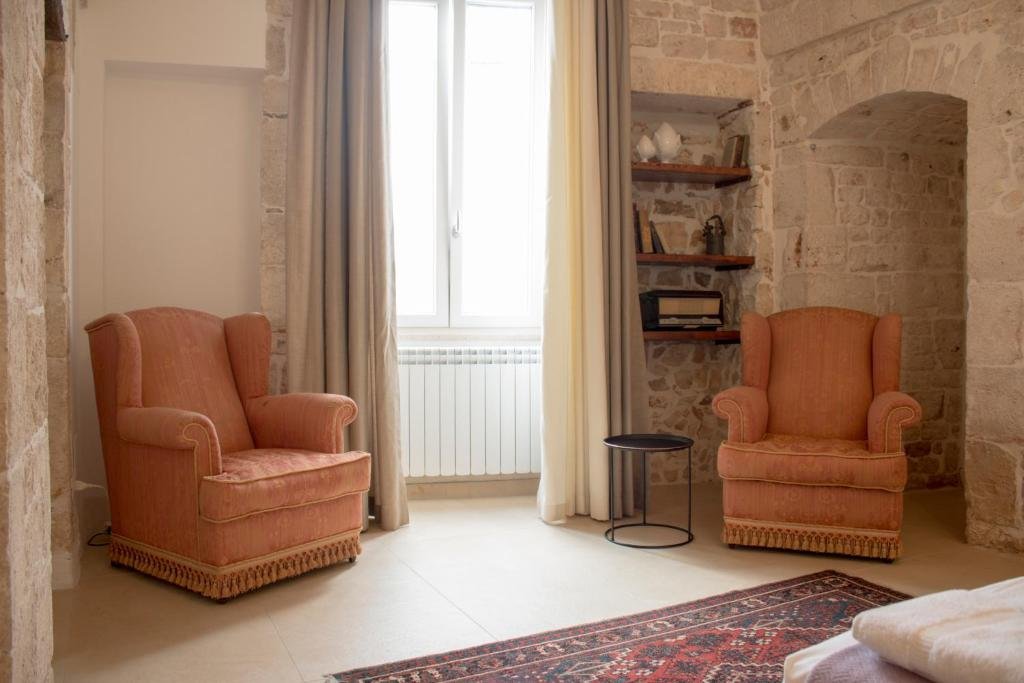 Salotto con poltrone e muri in pietra a Conversano